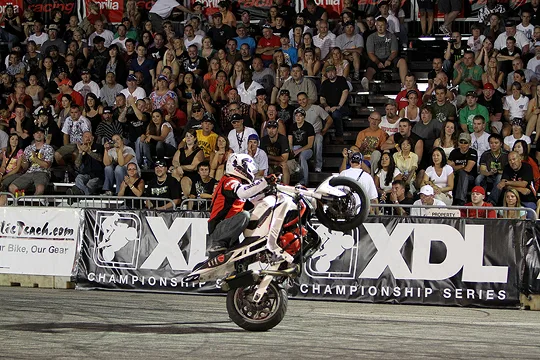 XDL rider holding a stoppie in front of the grandstands